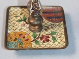 a small clock sitting on top of a plate on a table