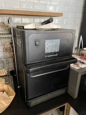 une photo d'une cuisine avec un micro-ondes et du pain sur le plan de travail