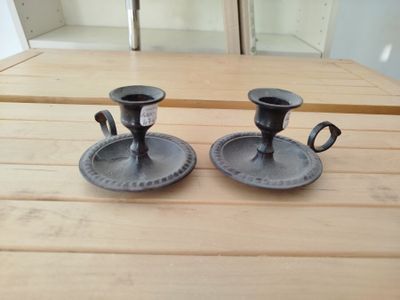 deux bougeoirs noirs posés sur une table en bois
