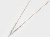 a pair of gold and diamond necklaces on a white background