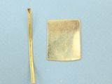 a piece of gold on a blue surface next to a piece of gold