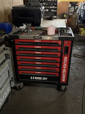 une boîte à outils posée dans un garage, avec des outils dessus
