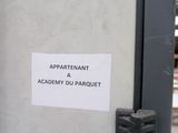 a sign on the door of a building that says appartenant academy du parquett