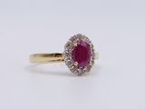 a close up of a ring with a ruby and diamond center