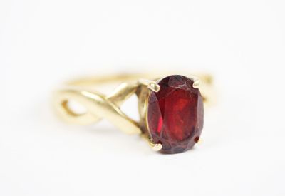 an image of a gold ring with a red stone in it
