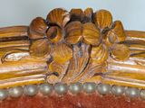 a close up of a wooden chair with a flower decoration on it