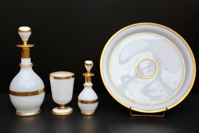 trois objets en verre blanc et doré posés sur une table