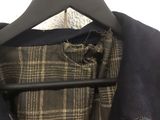 a coat hanging on a hanger with a tie