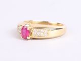 an image of a gold ring with a ruby stone and diamonds