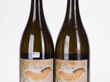 deux bouteilles de vin posées l'une à côté de l'autre sur une surface blanche