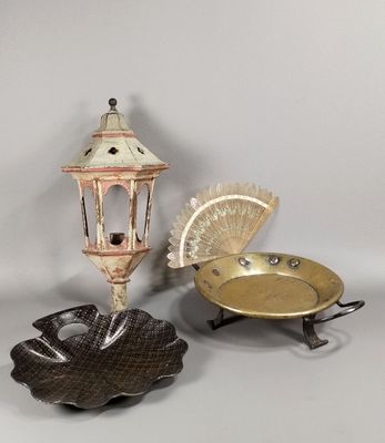 trois objets décoratifs sont exposés sur une surface blanche
