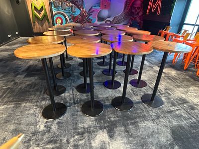 des tables et des tabourets dans une pièce où l'on peut voir une fresque murale