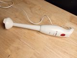 a white electric hand blender on a wooden table