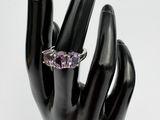 a hand with a ring on it that has a purple stone