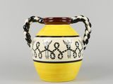 un vase jaune orné de motifs noirs et blancs