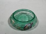 a green glass bowl with a fish inside of it
