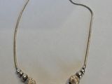 un collier de perles argentées sur un fond blanc