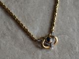 an image of a gold necklace with a heart and a diamond on it