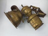 three antique brass lanterns on a white surface