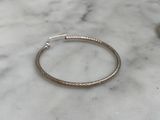 a close up of a silver bracelet on a marble surface