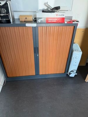 une armoire avec une porte et un micro-ondes posé sur le plan de travail