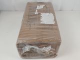 une boîte en carton emballée dans du plastique posée sur une surface blanche