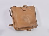 tan leather handbag on white background with a strap