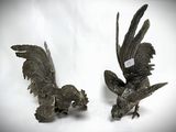 two metal birds that are standing next to each other