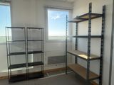 a room with shelves and a window in it