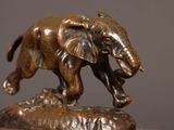 a bronze statue of an elephant standing on a rock
