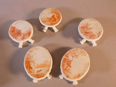 quatre petits bols et soucoupes blancs et orange posés sur une table