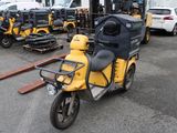 un scooter jaune et noir garé sur un parking