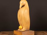 une sculpture en bois représentant un oiseau perché sur un bloc de bois