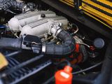 a close up of a car engine with a yellow truck in the background