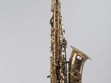 a saxophone hanging from a string on a wall