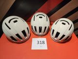 trois casques blancs posés les uns à côté des autres sur une table