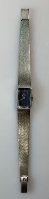 a silver wrist watch with a blue face on a white surface