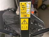 a black and yellow sign on a pole in a garage