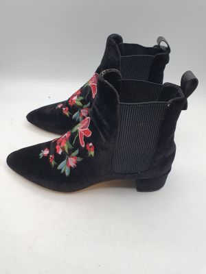 une paire de bottines noires en daim ornées de fleurs brodées sur le côté