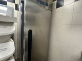 une photo d'un réfrigérateur en acier inoxydable dans une salle de bains