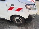 a white van with red stripes parked in a parking lot
