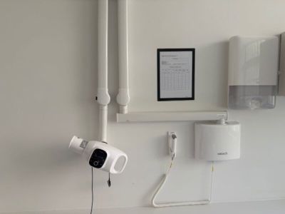 a picture of a bathroom with a toilet and a wall mounted camera
