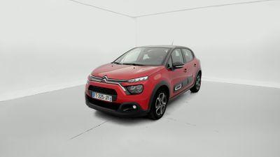 Une Citroën rouge est garée dans une pièce blanche