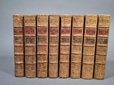 six vieux livres sont alignés sur une surface grise