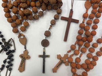 many different types of beads and crosses on the table
