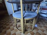 a small table with four chairs on it in a room