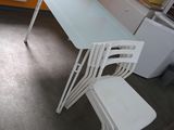 une table et des chaises blanches dans une petite pièce