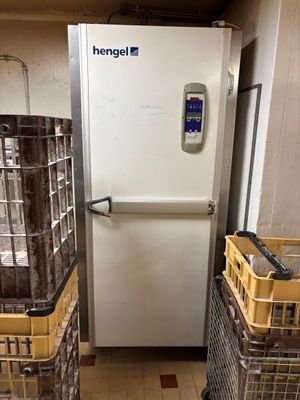a refrigerator that is next to some baskets on the floor