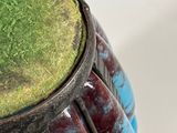 close up of a vase with a green top and a blue base