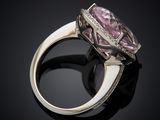 a close up of a pink diamond ring on a black surface